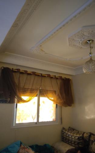 Zimmer mit einem Fenster mit einem Vorhang und einem Sofa in der Unterkunft Dar Al Menzeh in Beni Mellal