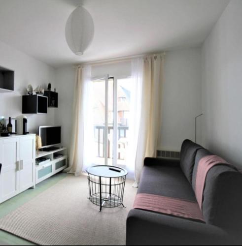 un salon avec un canapé et une table dans l'établissement Charmante villégiature à 150m de la plage, à Cabourg