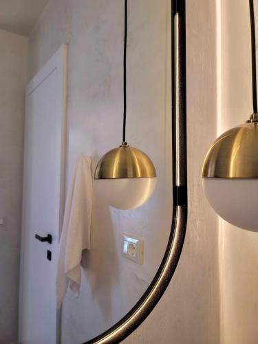 a bathroom with three lights and a mirror at Artis Blue Relax in Himare