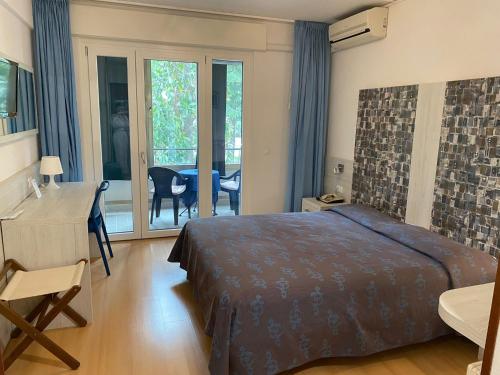 Schlafzimmer mit einem Bett, einem Schreibtisch und einem Tisch in der Unterkunft Hotel Meublè Villa Patrizia in Grado