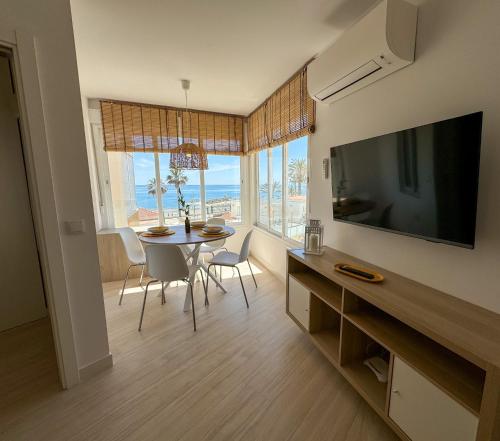 uma sala de estar com uma mesa de jantar e uma televisão em Apartment Avril by Spain2home em Torrox Costa