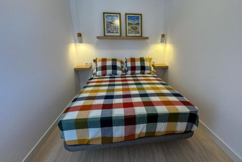 um quarto com uma cama colorida e 2 almofadas em Apartment Avril by Spain2home em Torrox Costa