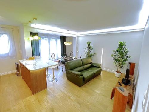 a living room with a green couch and a table at Appart Cosy tt confort - Sceaux - 20mn de Paris in Sceaux