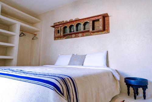 a bedroom with a bed and a shelf on the wall at Villa Madame Babouche, chambre Tanirt, SdB privative in Oulad el Madani