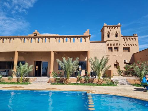 a house with a swimming pool in front of it at Auberge Famille Benmoro in Skoura
