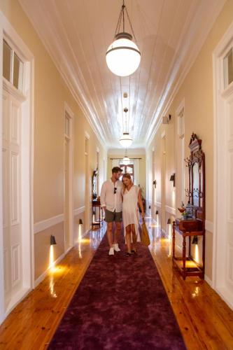 a man and a woman walking down a hallway at Rasim Palas - Adults Only in Cesme