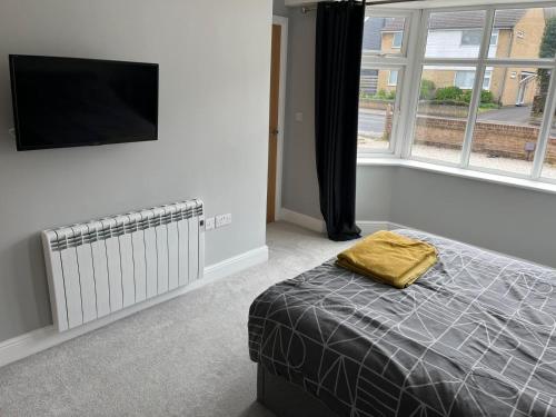 a bedroom with a bed and a flat screen tv at 1 bedroom ground floor apartment in Southbourne