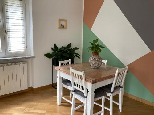 a dining room with a table with chairs and a plant at La Piana Vigezzo Santa Maria Maggiore Piano Terra con giardino in Santa Maria Maggiore