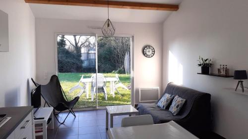 un salon avec un canapé et une table dans l'établissement MAISON ROUGE LE PONANT, à Châtelaillon-Plage
