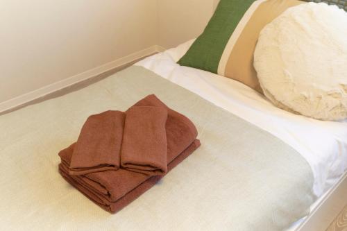 a pile of towels sitting on top of a bed at Fiore Kinshicho by Tranova in Tokyo