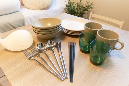 a wooden table with plates and utensils on it at Fiore Kinshicho by Tranova in Tokyo