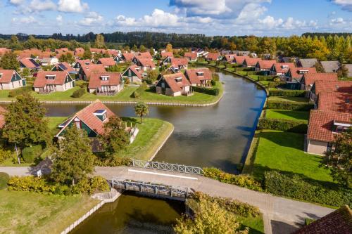 an aerial view of a suburb with houses and a river at Vakantiepark Hof van Zeeland in Heinkensand