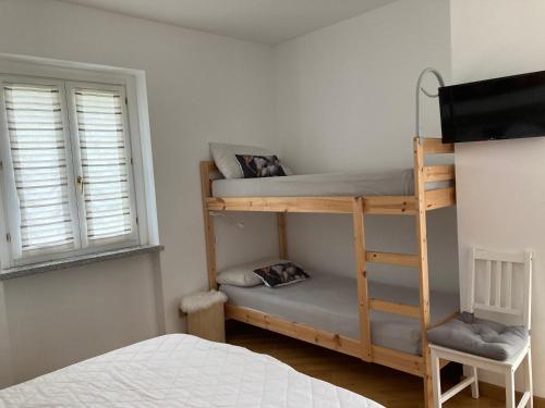 a bedroom with a bunk bed and a window at La Piana Vigezzo Santa Maria Maggiore Piano Terra con giardino in Santa Maria Maggiore