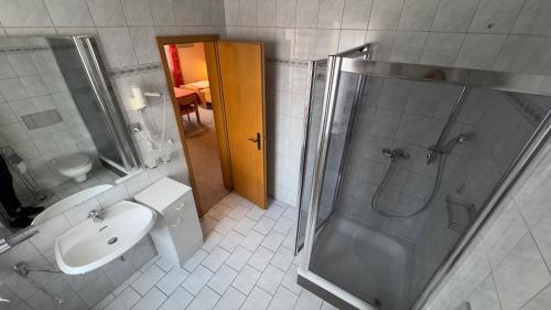 een badkamer met een douche, een wastafel en een toilet bij Pension Göppner in Bad Neustadt an der Saale