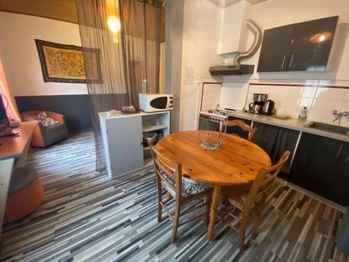 une cuisine avec une table en bois et une petite cuisine avec une table et des chaises dans l'établissement La Maisonnette du Jardin Caché, à Marmande