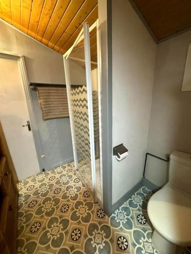 La salle de bains est pourvue de toilettes et de carrelage. dans l'établissement La Maisonnette du Jardin Caché, à Marmande