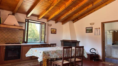 cocina con mesa, sillas y ventana en Chalet Contrada Difesa, en Maletto