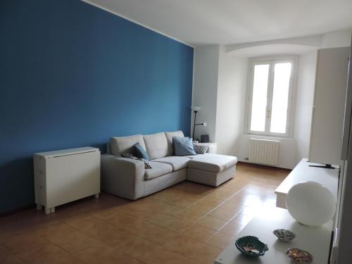 a living room with a white couch and a blue wall at Lungolago Malgrate in Malgrate