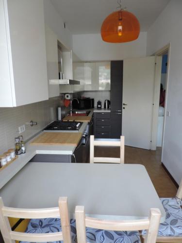 a kitchen with a white table and chairs at Lungolago Malgrate in Malgrate