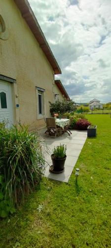 un patio con mesa y banco en GITE DE MIRAUVILLE, en Apremont-la-Forêt