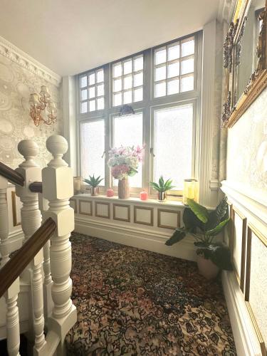 a room with a staircase and a window with flowers at ElMurrs in Bournemouth