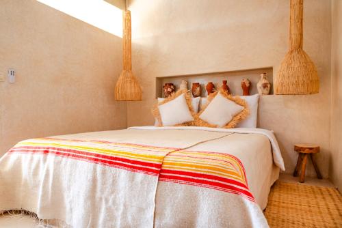 een slaapkamer met een bed met een kleurrijke deken bij Villa Madame Babouche, Studio Lahna, SdB privative in Oulad el Madani