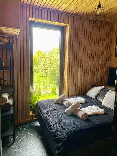 a bedroom with a bed with towels on it at Stodoła Na Kresach - widokowy domek drewniany, całoroczny JACUZZI & SAUNA in Bodzentyn