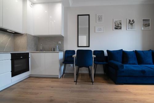 a living room with a blue couch and a table at Apartament2 Bulwar Staromiejski Stare Miasto Centrum in Wrocław