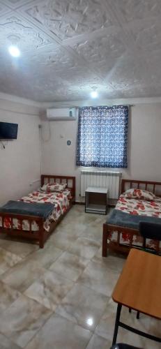 Cette chambre comprend 3 lits et une fenêtre. dans l'établissement Hostel 1 er novembre khenchela, à Khenchela