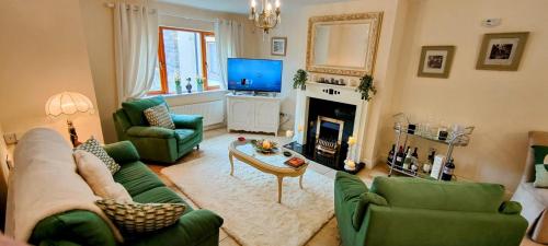 a living room with green furniture and a television at Lough Rynn in Mohill