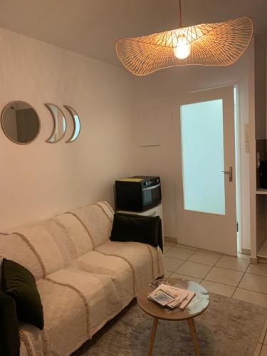 - un salon avec un canapé et une table dans l'établissement Appartement cossy 1 chambre pour 2 pers - rénové - terrasse - parking, à Dinard