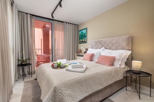 een slaapkamer met een groot bed met roze kussens bij Abau Residence Apartment 2 Opatija in Opatija