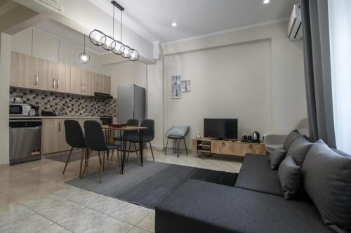 een woonkamer met een bank en een tafel met stoelen bij Μοντέρνο διαμέρισμα στο κέντρο in Orestiada