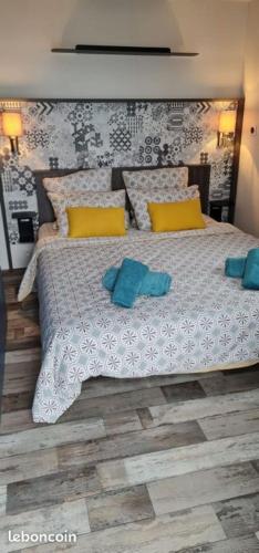 - une chambre dotée d'un grand lit avec des oreillers jaunes et bleus dans l'établissement Bungalow Mobile Home de Luxe Vue Mer Saint-Raphaël 4 personnes, à Saint-Raphaël