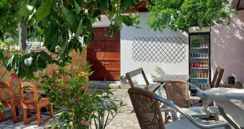 a patio with a table and chairs and a book shelf at Niku HomeStay in Berat