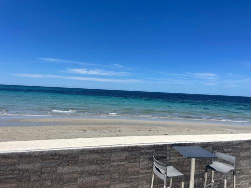 - une table et deux chaises à côté de la plage dans l'établissement SUITEBEACH b&b and resort, à Marsala