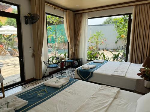 two beds in a room with a large window at Azalea Tam Coc Ninh Bình in Ninh Binh