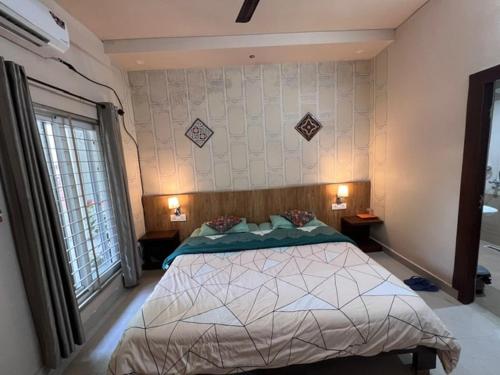 a bedroom with a bed and two lamps and a window at GREEN HOME STAY in Lucknow