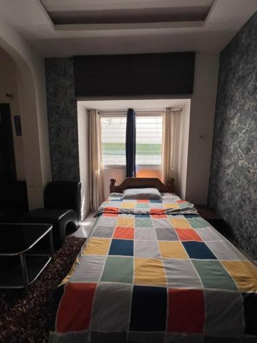 a bedroom with a bed with a colorful quilt on it at GREEN HOME STAY in Lucknow