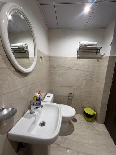 a bathroom with a sink and a toilet and a mirror at GREEN HOME STAY in Lucknow