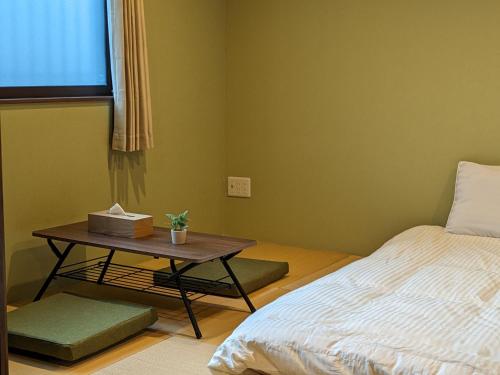 a room with a bed and a table with a bed gmaxwell gmaxwell gmaxwell at Private Villa Tofukuji in Kyoto
