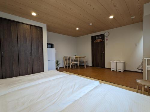 a bedroom with a large white bed and a table at Private Villa Tofukuji in Kyoto