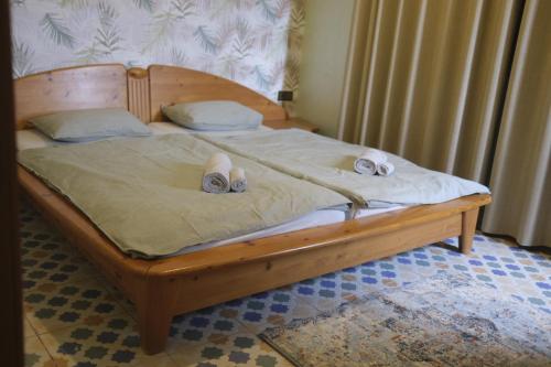 a wooden bed with two pairs of shoes on it at Villa Casa Jasmin in Melîyech