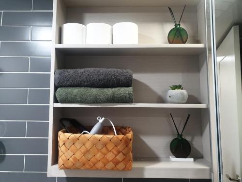 a bathroom shelf with towels and a basket on it at Walking gate camp Humphreys in Pyeongtaek