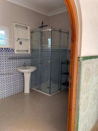a bathroom with a glass shower and a sink at Villa Casa Jasmin in Melîyech