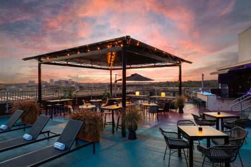 a rooftop patio with tables and chairs at sunset at The Ven at Embassy Row, Washington, D.C., a Tribute Portfolio Hotel in Washington
