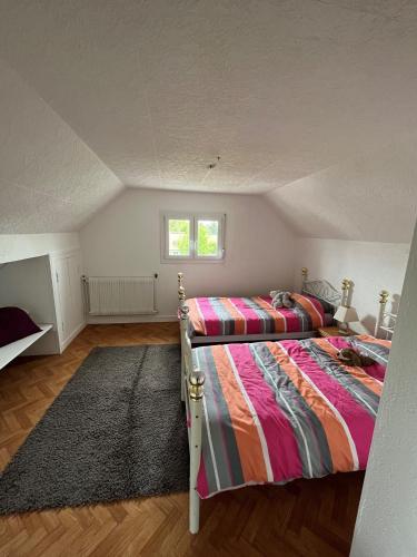 une chambre avec deux lits et une fenêtre dans l'établissement La maison familliale, à Garancières