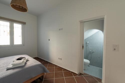 a bedroom with a bed and a bathroom with a shower at Memories Gytheio in Gythio