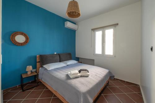a bedroom with a bed with a blue wall at Memories Gytheio in Gythio