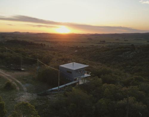 a building on a hill with the sunset in the background at Villa Toscana I - Gran Vista y Tranquilidad in Villa Serrana